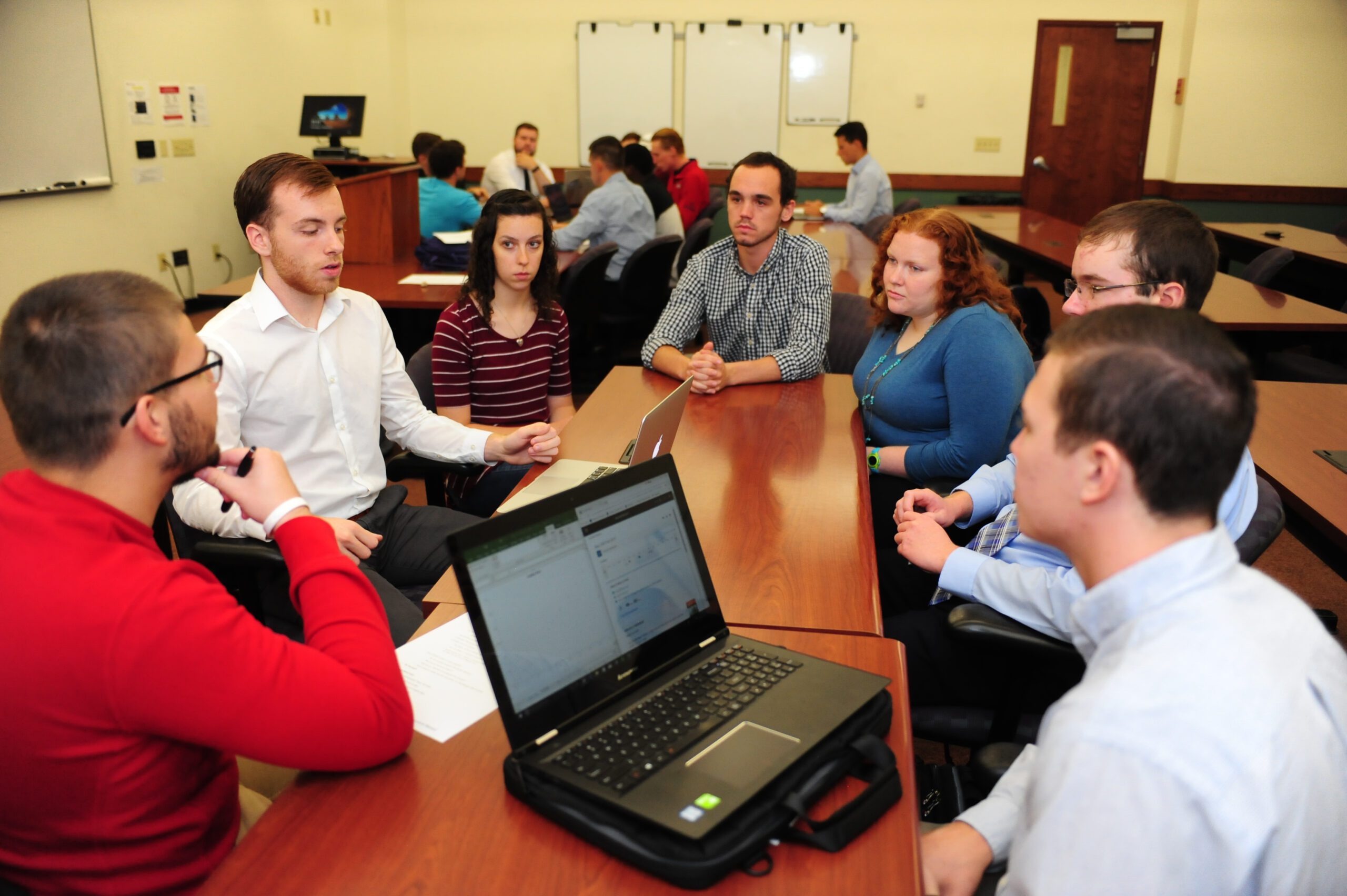 Students gathered around a table for a degree in business administration