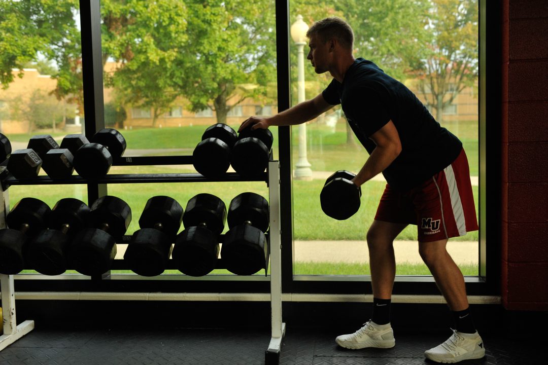 Exercise science degree student lifting weights.